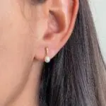 Aro Elise, de oro amarillo 18k con perla, puesto en modelo.