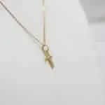 onjunto de joyería fina en oro 18k con colgante cruz brillante.