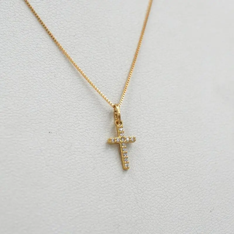 Colgante de cruz en oro amarillo 18k con circones brillantes.