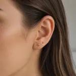 Abridores Bolita de Oro Amarillo 18K puestos en la oreja de una modelo