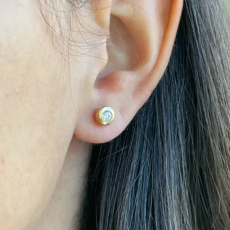 Aros Punto de Luz Oro Amarillo 18K de 6 mm puestos en la oreja
